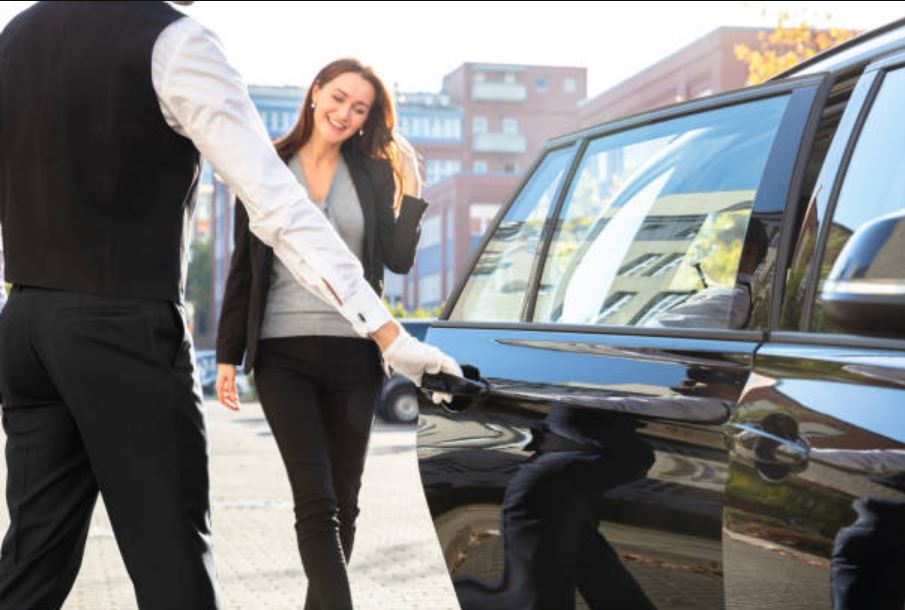 chauffeur privé ouvre la porte à une cliente